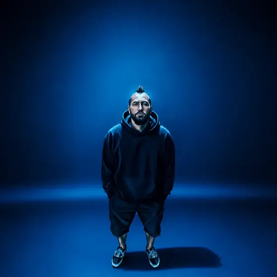 Vitor Gates de pé sob luz azul