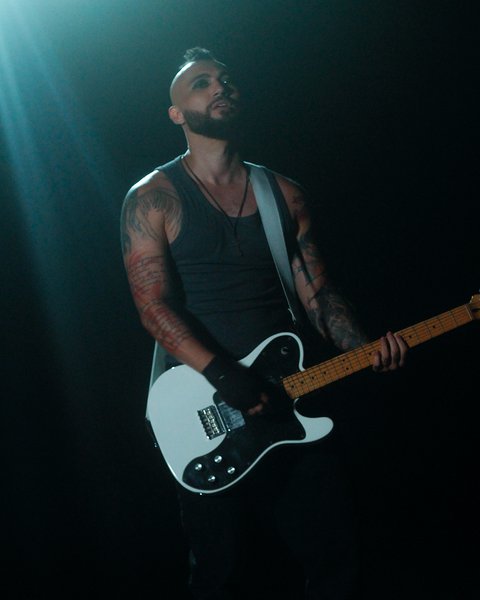 Vitor Gates em 2025, em show com guitarra elétrica sob luz dramática
